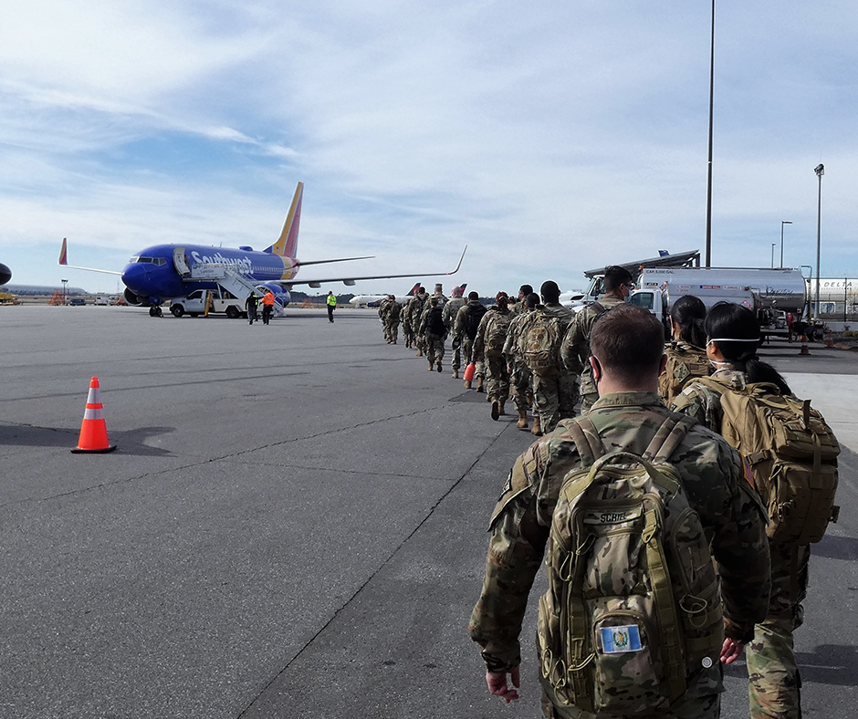 Photo of reserve soldiers loading into a commercial airplane.